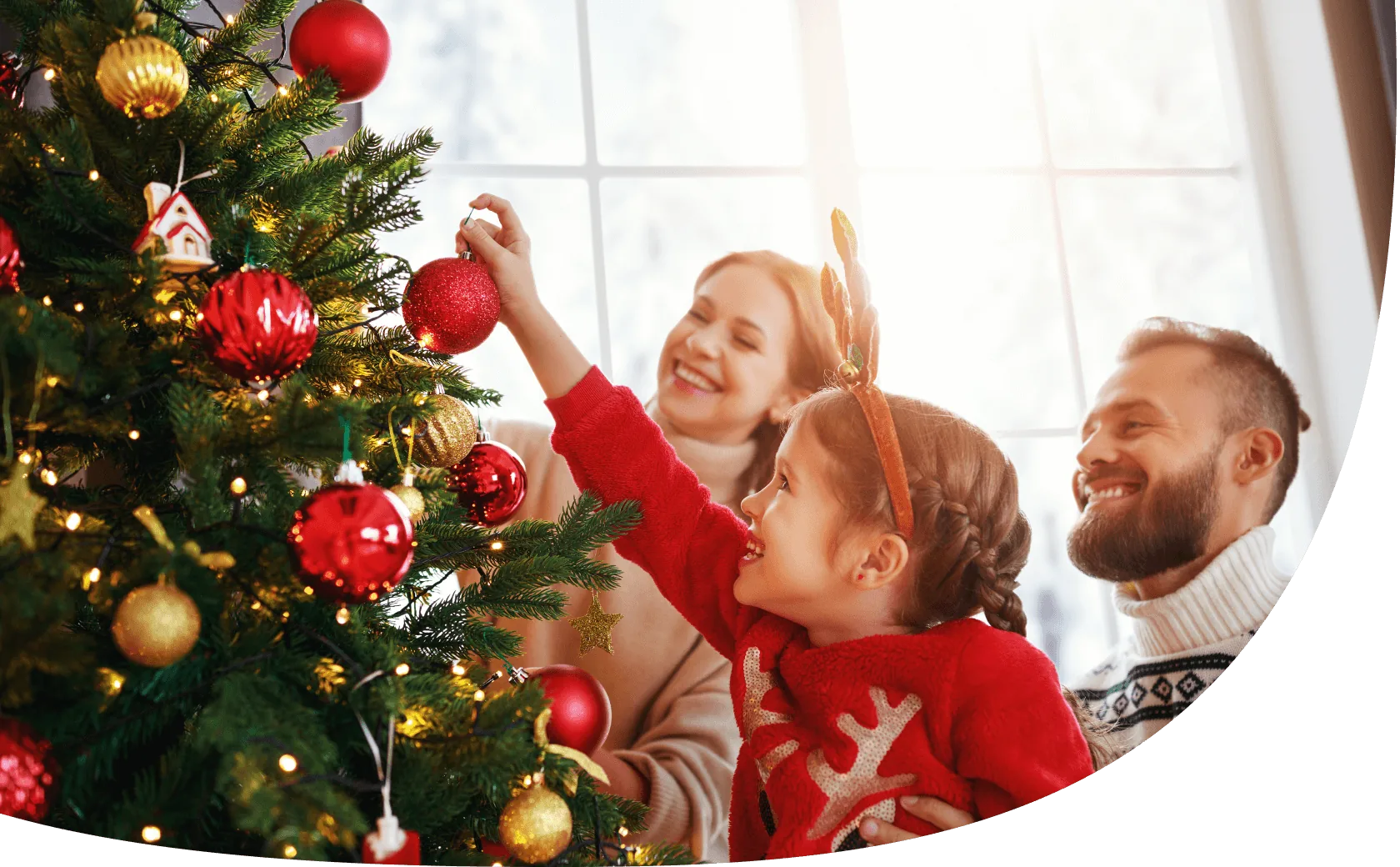 Kind und Eltern schmücken den Baum für Weihnachten