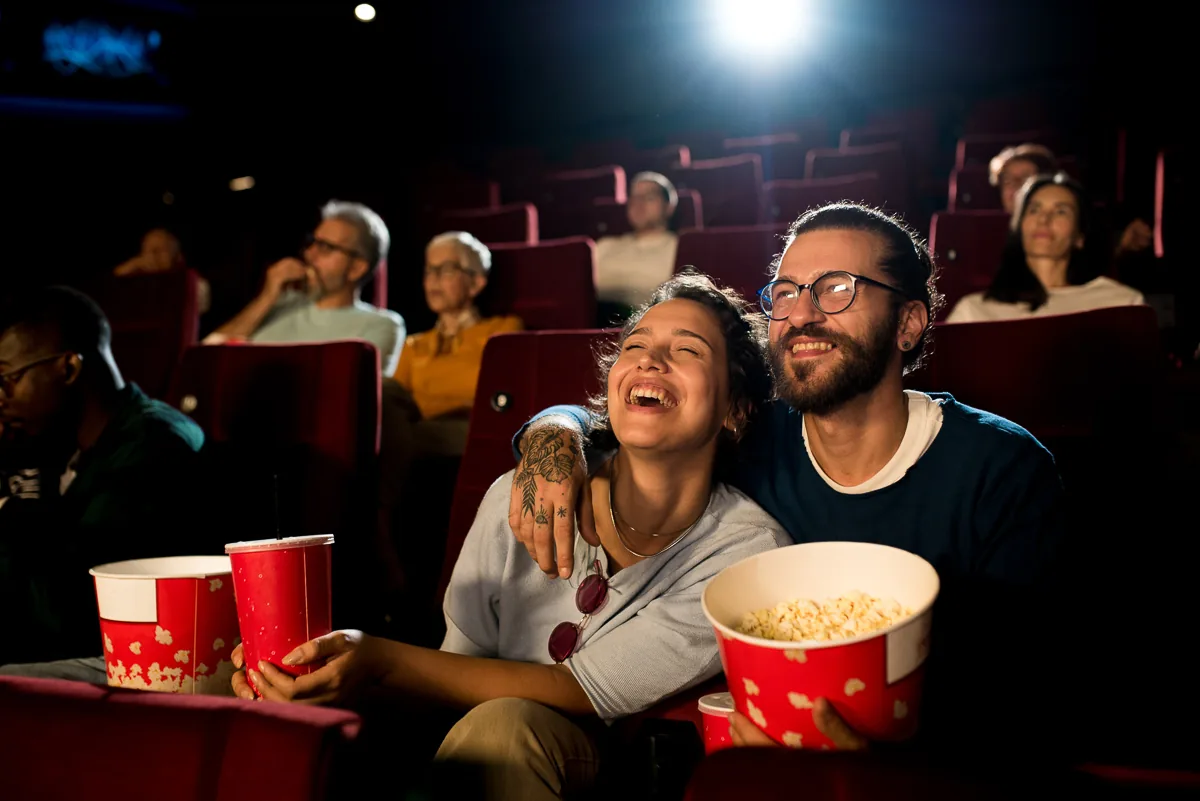 Junges Paar sieht sich einen Film im Kino an und genießt ihn.