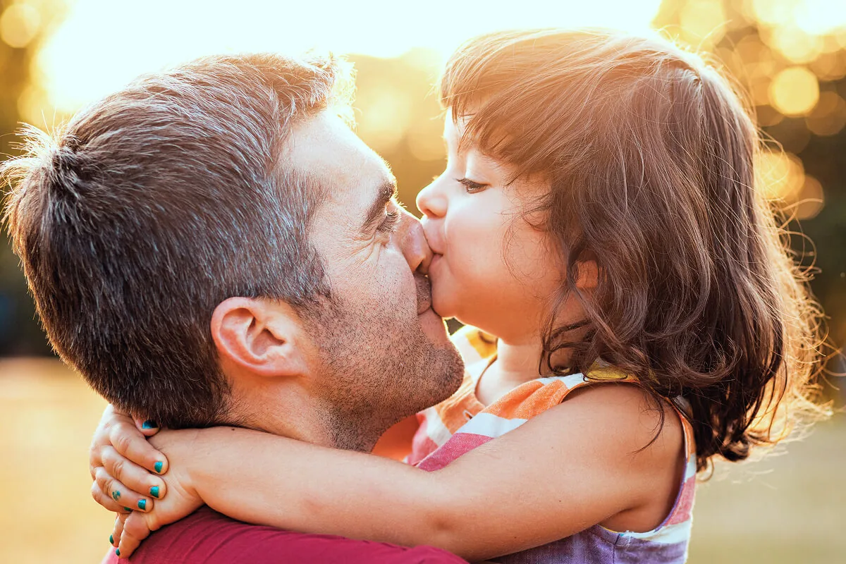 Vater kuschelt mit seiner Tochter