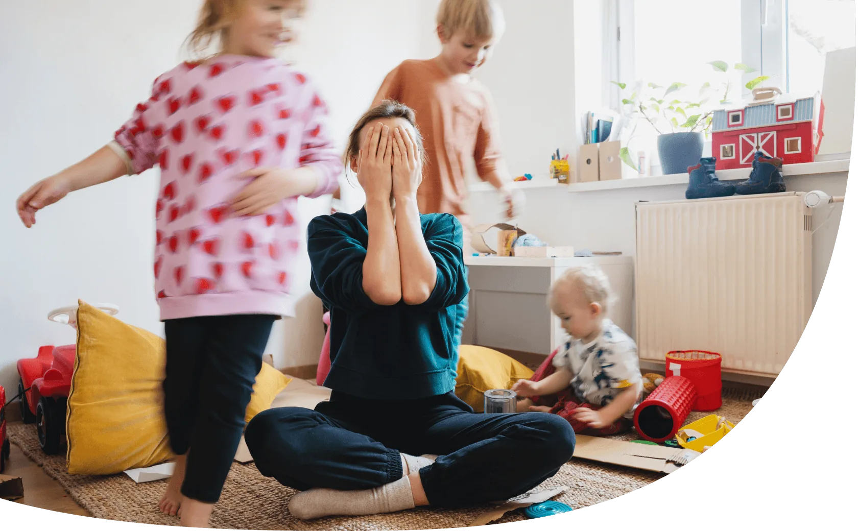Eine überforderte Mutter ist im Kinderzimmer mit ihren drei Kindern